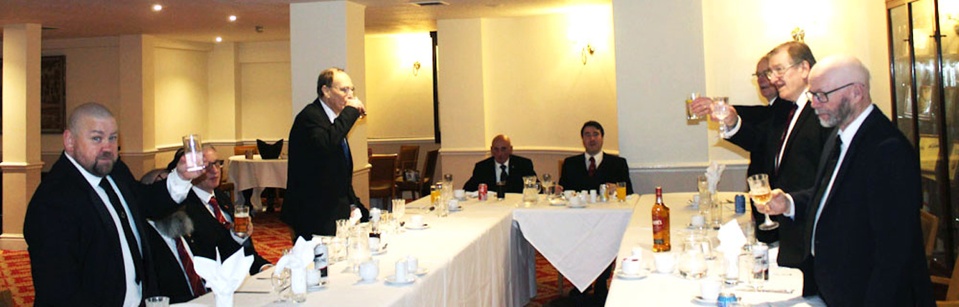 Three principals (right) toast the two candidates, Ian Byron (standing left) and Edward Jordon (standing second left).