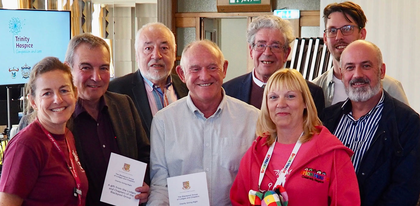 Members of lodges presenting cheques to representatives from Trinity Hospice.