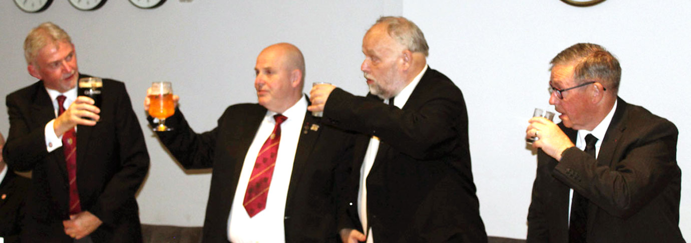 The three principals toast the health of Ian Stirling (left).