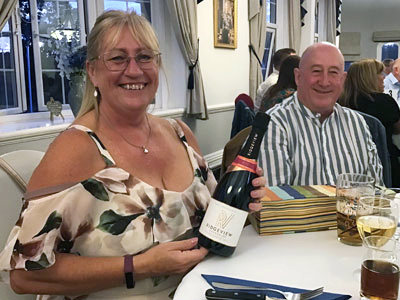 Lucky bottle draw winner Gail Dawson (left) with her winning bottle, alongside her partner Roger Harrison.