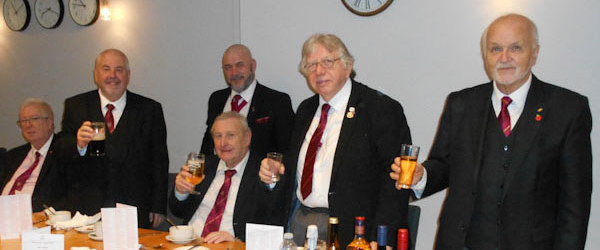 Christopher (standing left) receiving a toast from the three principals.