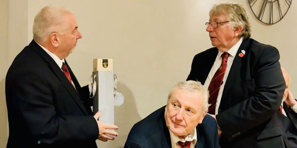 Christopher (left) receiving gift from Alan on behalf of the chapter.