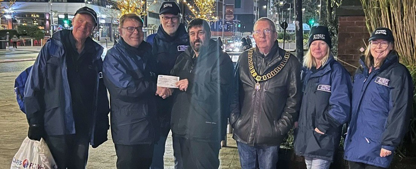 Tim Horton (centre) presents the cheque to Paul Blackett (second left), watched on by the Mayor of Preston Councillor Phil Crowe and the Street Pastors team.