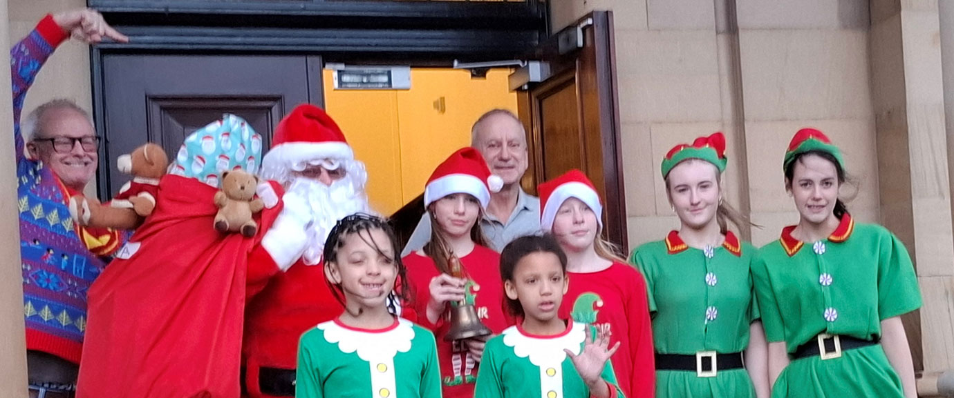 Santa tries to sneak into the hall with his elves and the Group Vice Chairman Brian Griffiths, as Southport Group Chairman Phil Stock (left) fails to contain his excitement.