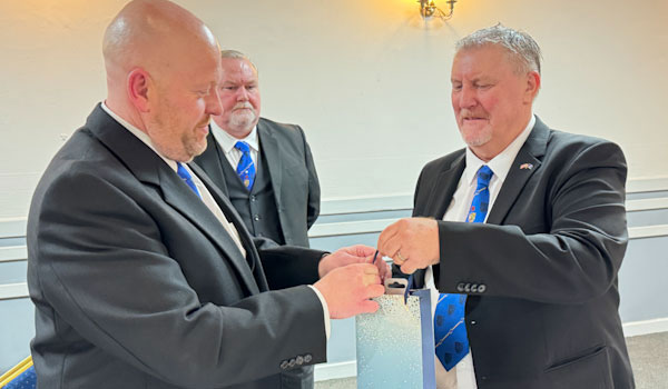 Malcolm (left) receives a thank you gift from Mick.