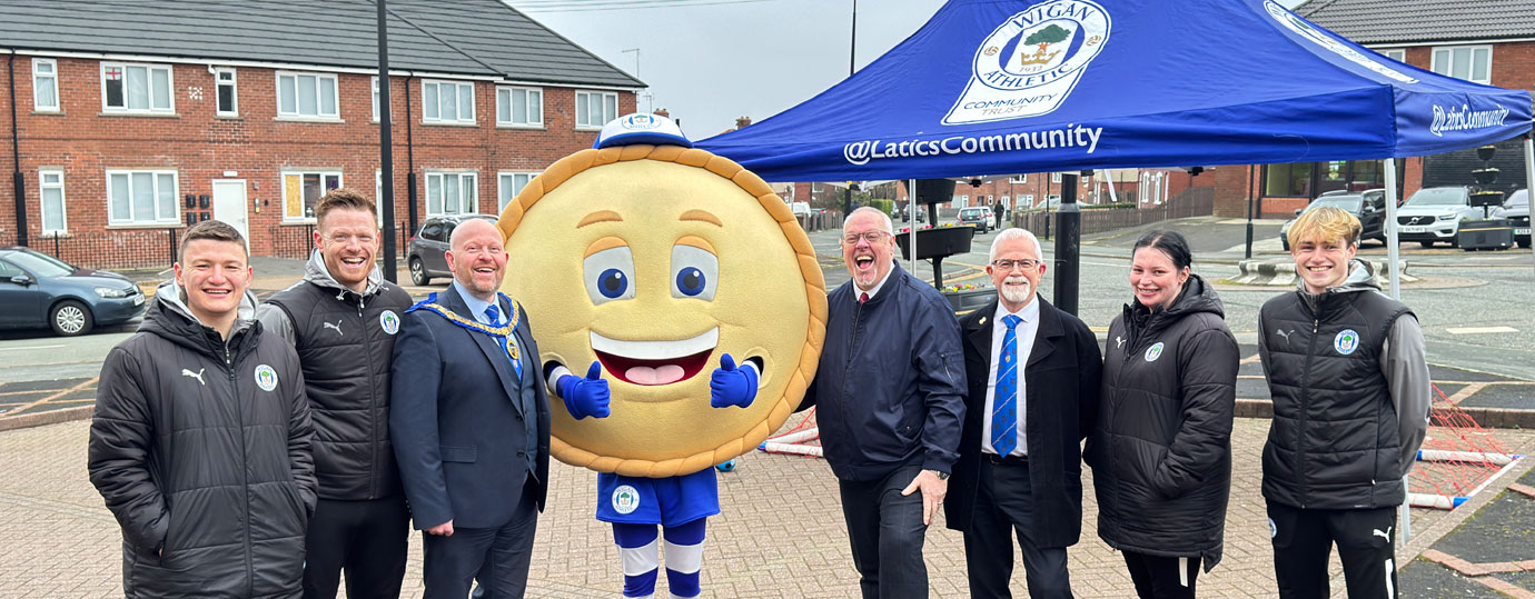 Crusty, the Wigan mascot, meets the team.