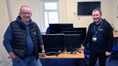 John Hardman (left) presenting used televisions to Stephen Grimshaw of Homeless Action.