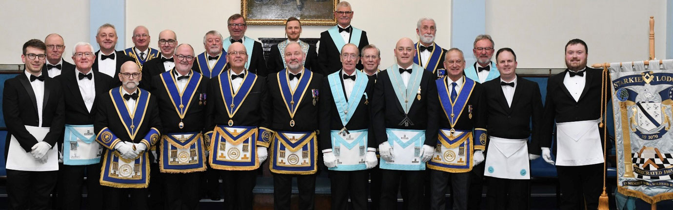 The brethren of Starkie Lodge gather in celebration around Adam Bicknell following his installation as WM.