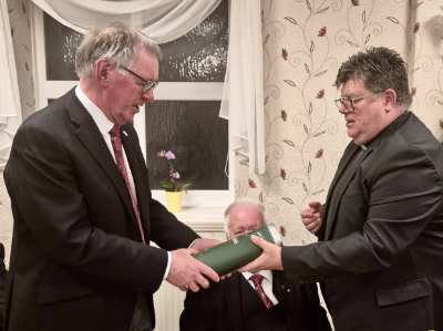 John Robbie Porter (left) receiving a bottle of whisky from John Hall.