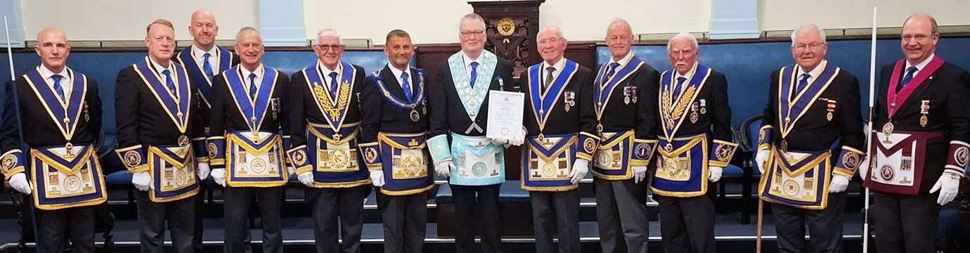 Geoff and Peter McPhail hold the certificate surrounded by esteemed guests.