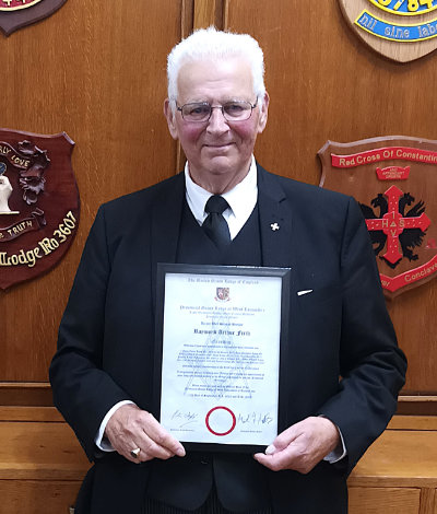 Ray Firth proudly displays his certificate.