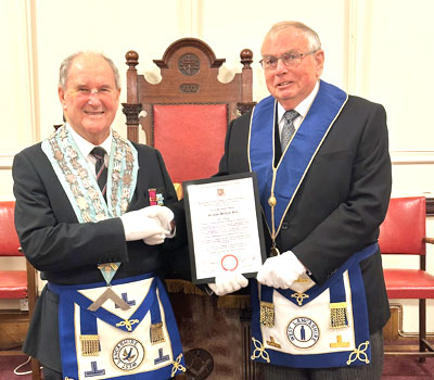 Don Fraser (lefty) congratulates Graham Bull on his golden jubilee.