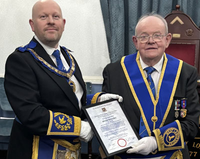 Malcolm Bell Jnr (left) presents Malcolm Bell Snr with his 50th anniversary certificate.