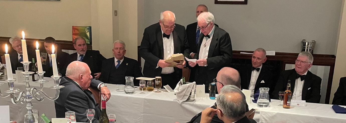 Stuart Cunningham (standing right) presents Phil Gunning with a gift from the lodge.