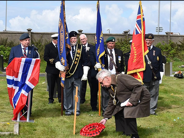 Councillor Steve Nicholls places the first wreath.